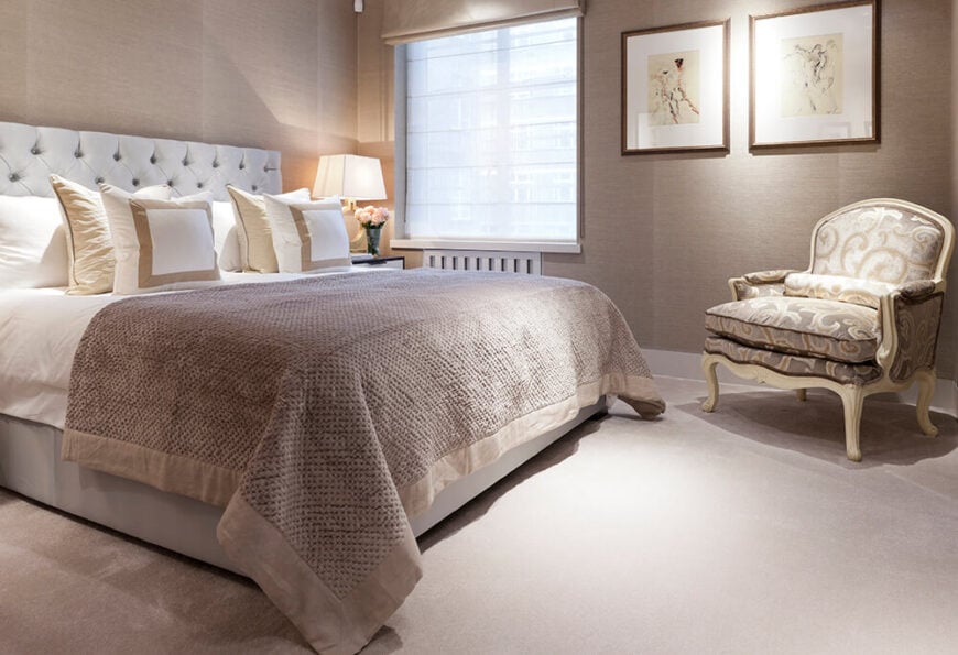第二间卧室采用了更为中性的暗米色色调，突出了木雕扶手椅和纽扣簇绒床头板的传统优雅。