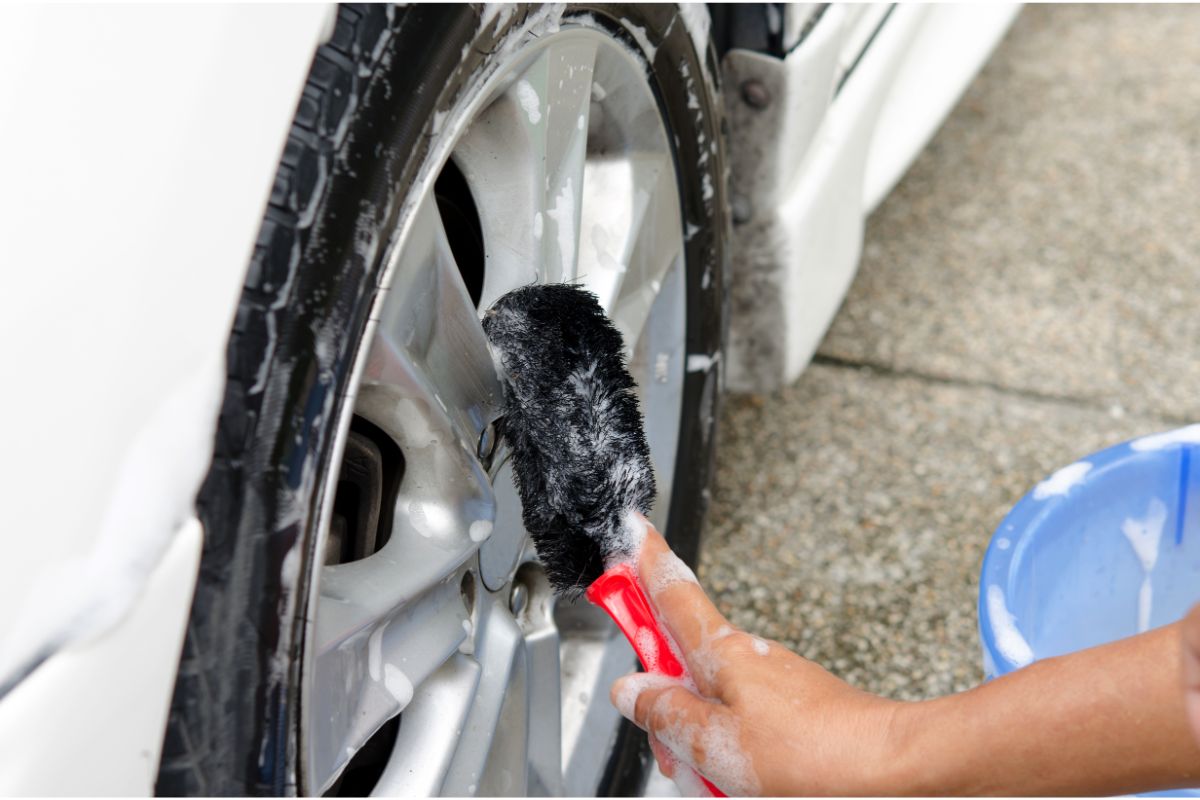 一名男子使用滚轮刷清洁他的汽车的特写照片。