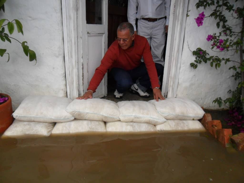 一名男子将“洪水萨克斯”堆在门前的地上，防止泥泞的洪水进入他的房子。