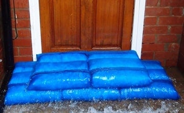 放置在住宅前门前的防洪袋，防止洪水泛滥。