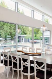用餐区位于客厅的后面，由一对透明的玻璃球形挂件和自然光线穿过玻璃窗照亮。