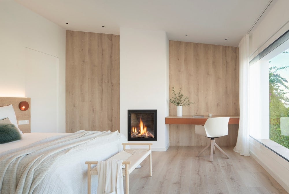 主卧室有一个白色的漆天花板,木质地板,一个定制的壁炉。