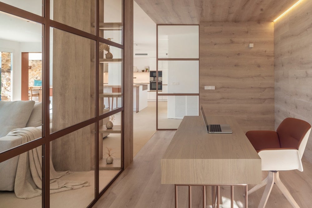 矩形柞木表铜桌腿和软垫椅在一楼的办公室。