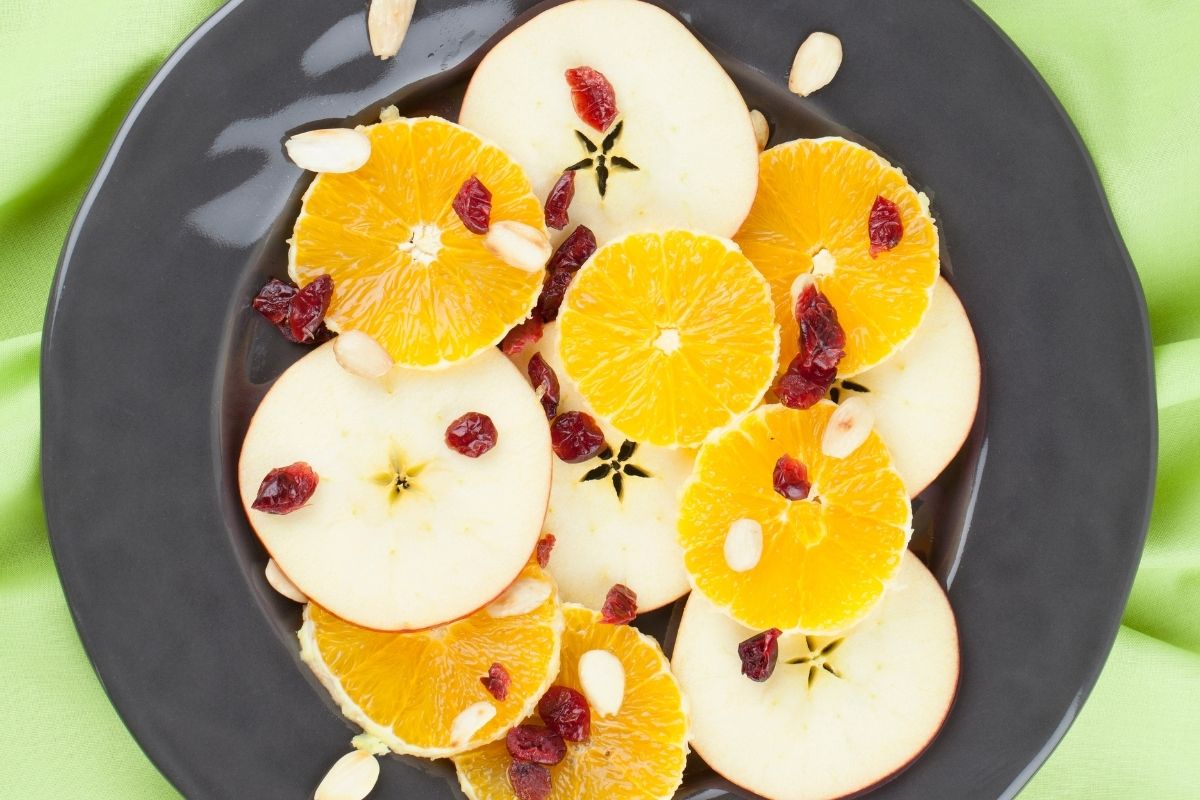 健康的苹果和橘子沙拉与蔓越莓干的俯视图。