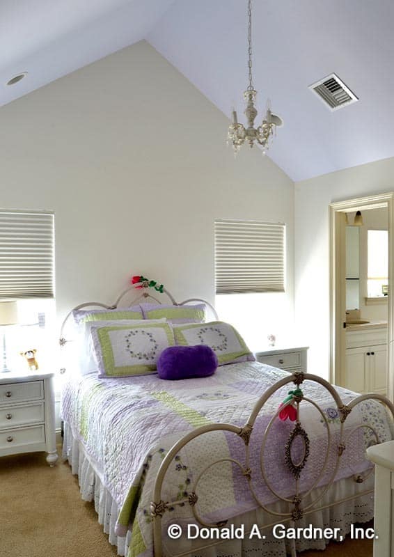 这卧室功能一个华丽的金属床两侧是白色的床头柜和窗户。
