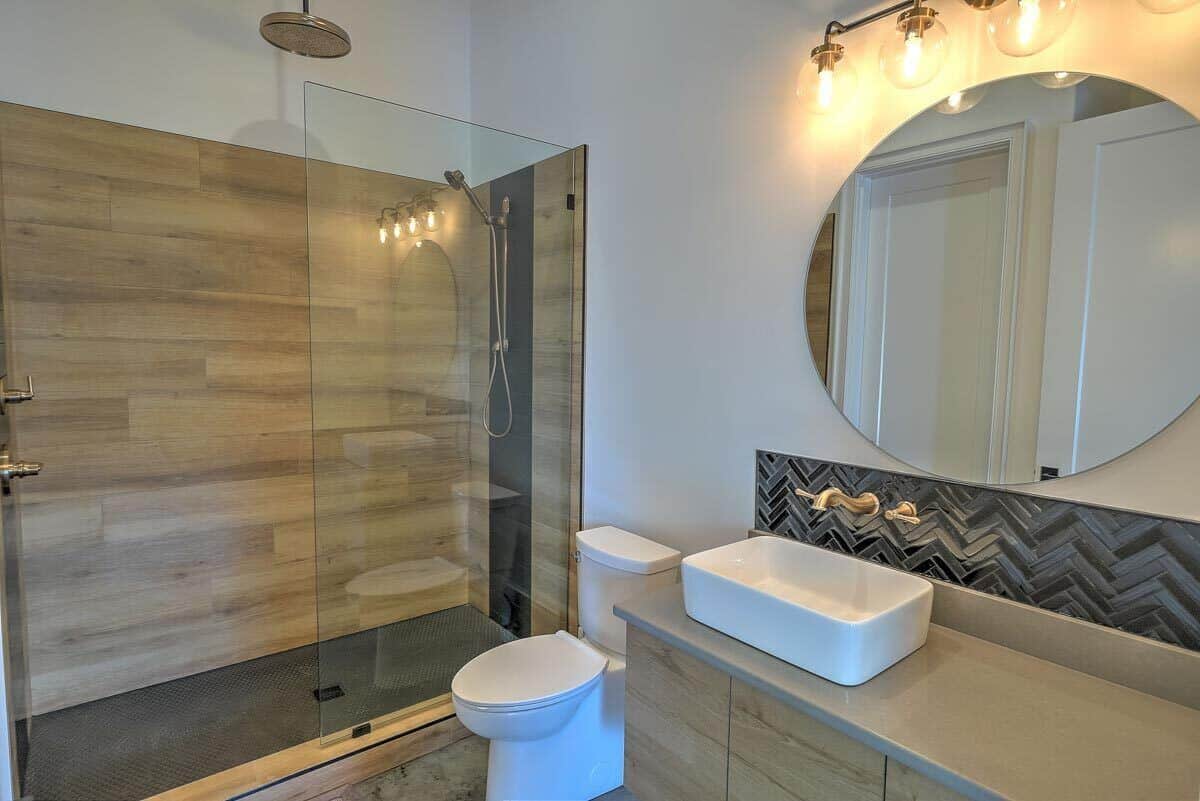 这间浴室提供一间步入式淋浴间和一个由温暖的壁灯照亮的容器水槽梳妆台。