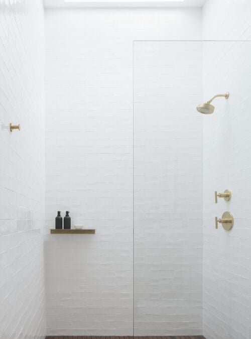 一个特写的照片在浴室里淋浴区,突出淋浴和玻璃墙分压器作为主要的焦点。